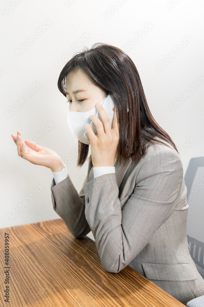 Woman wearing a mask worried about work phone Woman wearing a mask worried about work phone