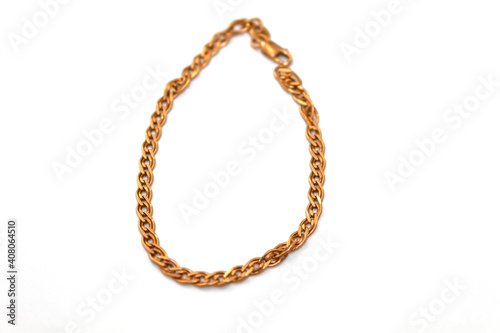Women's bracelet made of gold lies on a white background