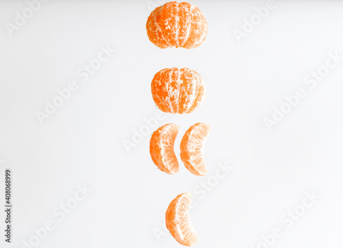 Fresh peeled tangerine flying in the air isolated on white background. Food levitation concept. Healthy food, ripe fruits, citrus fruits.Copy space