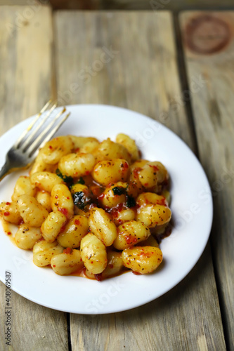 Soft focus. Gnocchi with red sauce on a white plate.