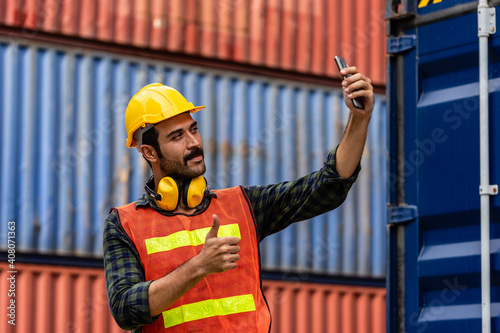 Caucasian worker in safety vest reflective with Safety helmet selfie himself with mobile phone