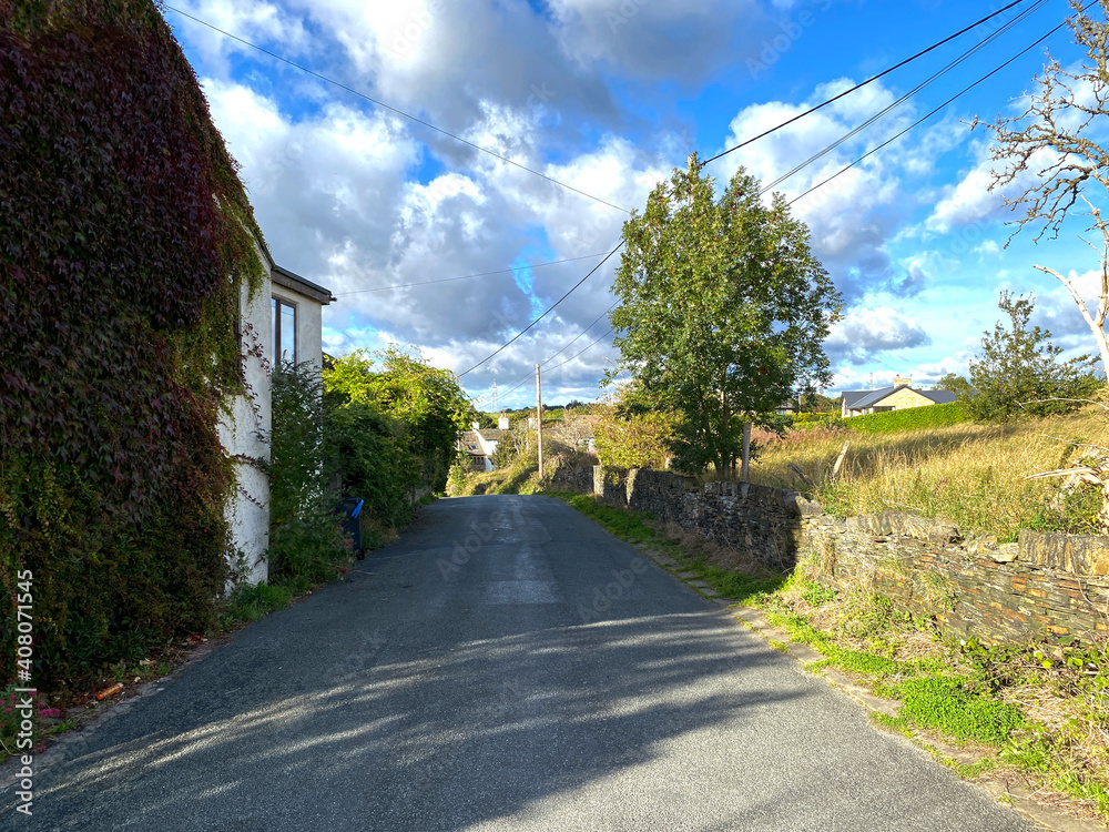 Looking down, Thornhills Lane, with dry stone walls, buildings and trees in, Clifton, Brighouse, UK Looking down, Thornhills Lane, with dry stone walls, buildings and trees in, Clifton, Brighouse, UK