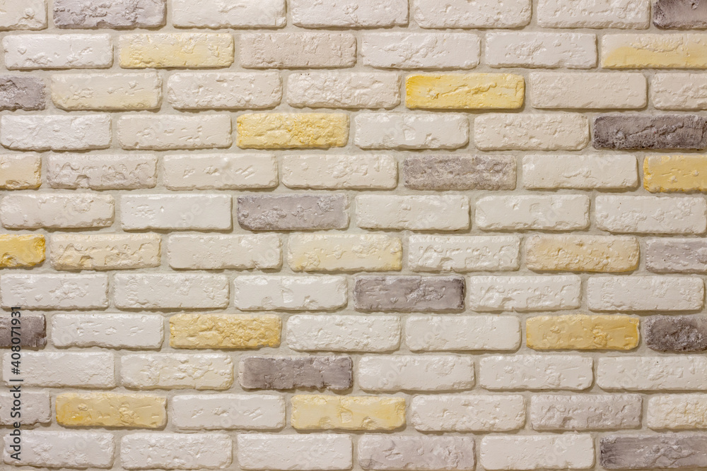 Wall with decorative plaster facing bricks following the example of antique tiles in white, yellow and gray. Original background, pattern for graphic works and design Wall with decorative plaster facing bricks following the example of antique tiles in white, yellow and gray. Original background, pattern for graphic works and design