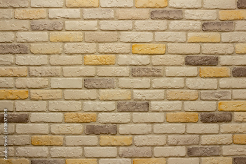 Wall with decorative plaster facing bricks following the example of antique tiles in white  yellow and gray. Original background  pattern for graphic works and design