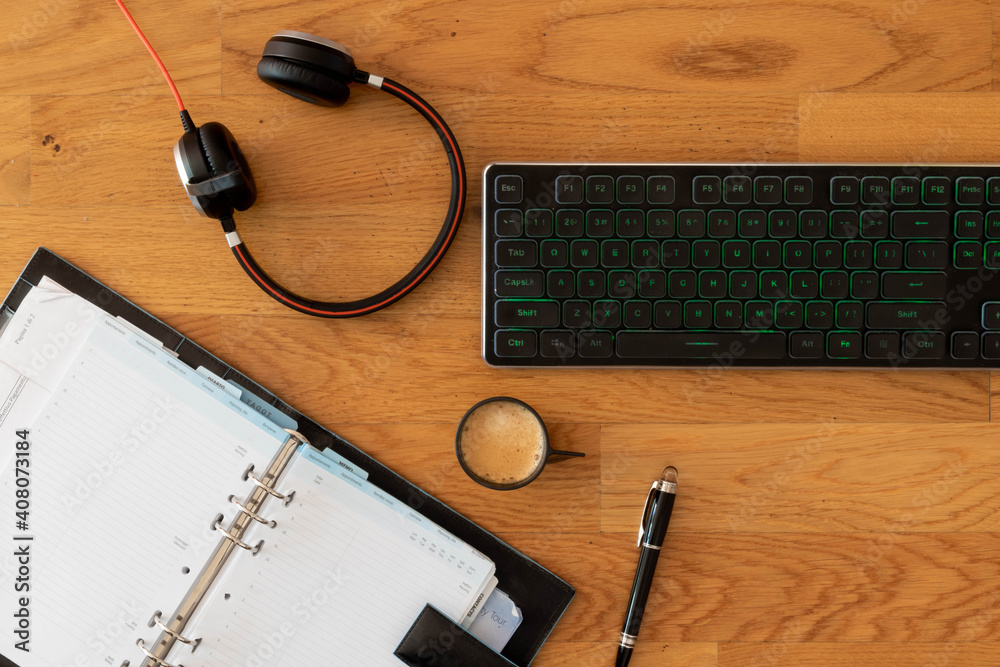 Smart working desktop with laptop, headset, agenda and coffee