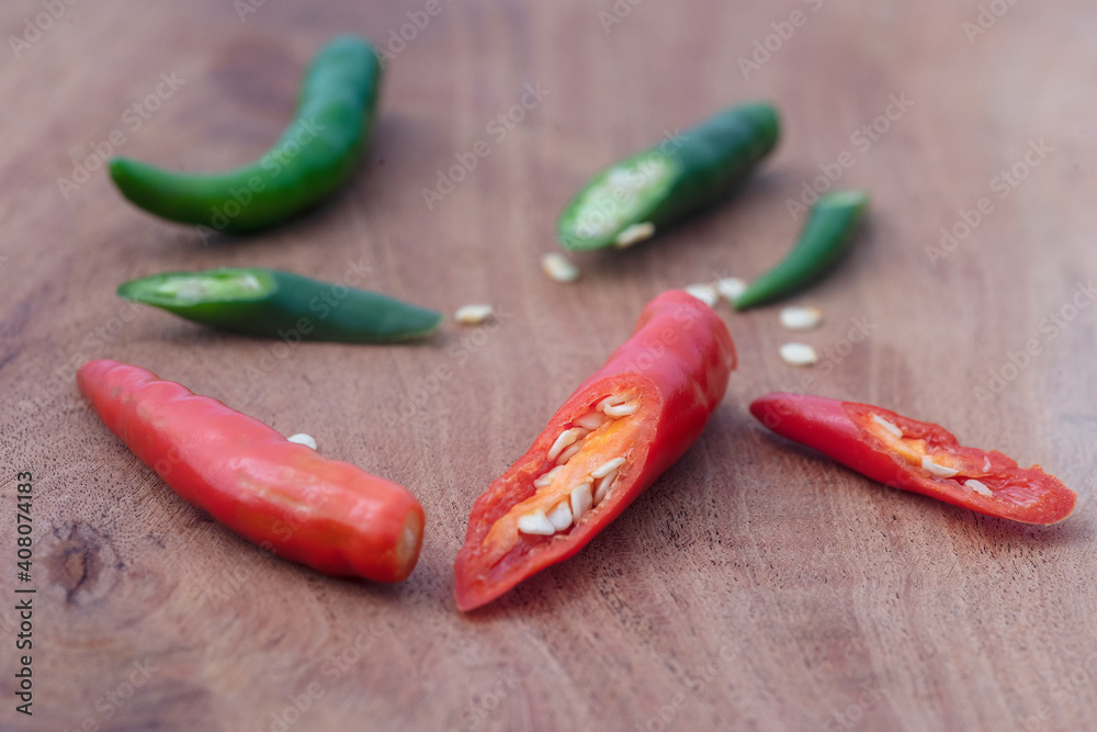 Red and green chillies alternately placed on a wooden cutting board