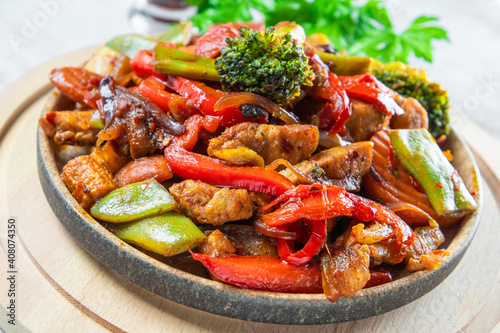 Stewed vegetables with meat on a plate close up