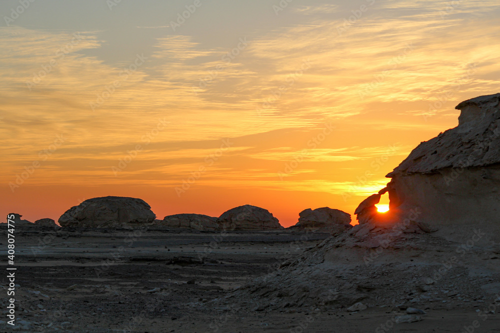 Sun rising in the Libyan desert, uncovering bizarre limestone formations, near Farafra in Egypt