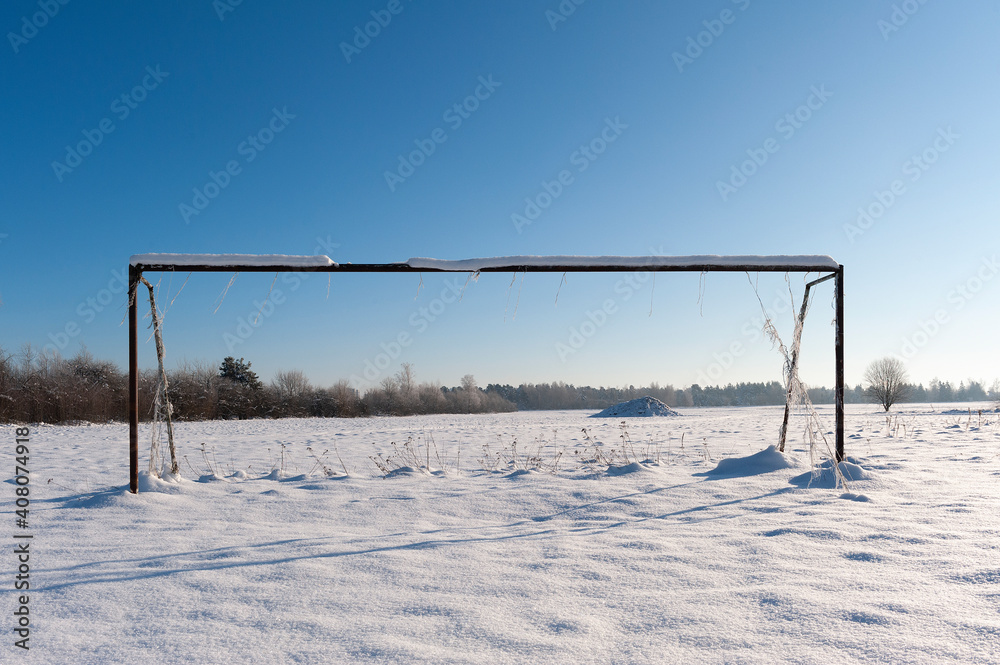 Winter landscape. Football goal of a school playground in the snow. sunny day Winter landscape. Football goal of a school playground in the snow. sunny day