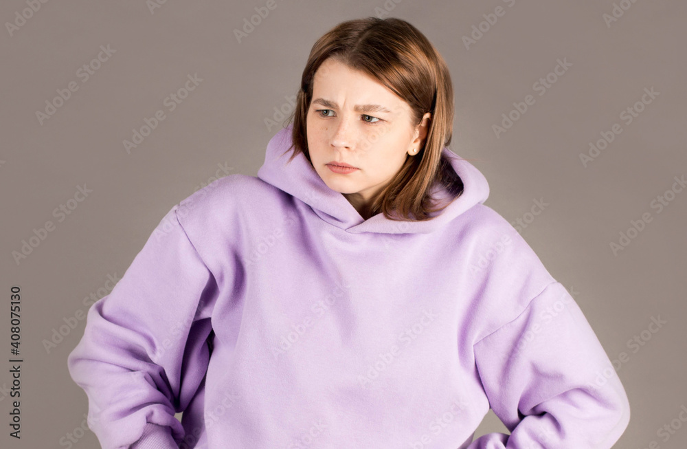 Hmm. Let me think. Studio shot of cute girl with freckles looking sideways with thoughtful and sly expression Hmm. Let me think. Studio shot of cute girl with freckles looking sideways with thoughtful and sly expression