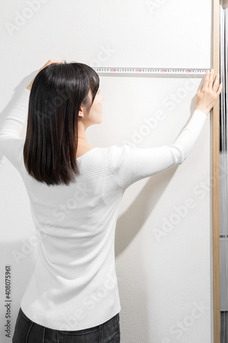 Standing woman measuring with a tape measure photo