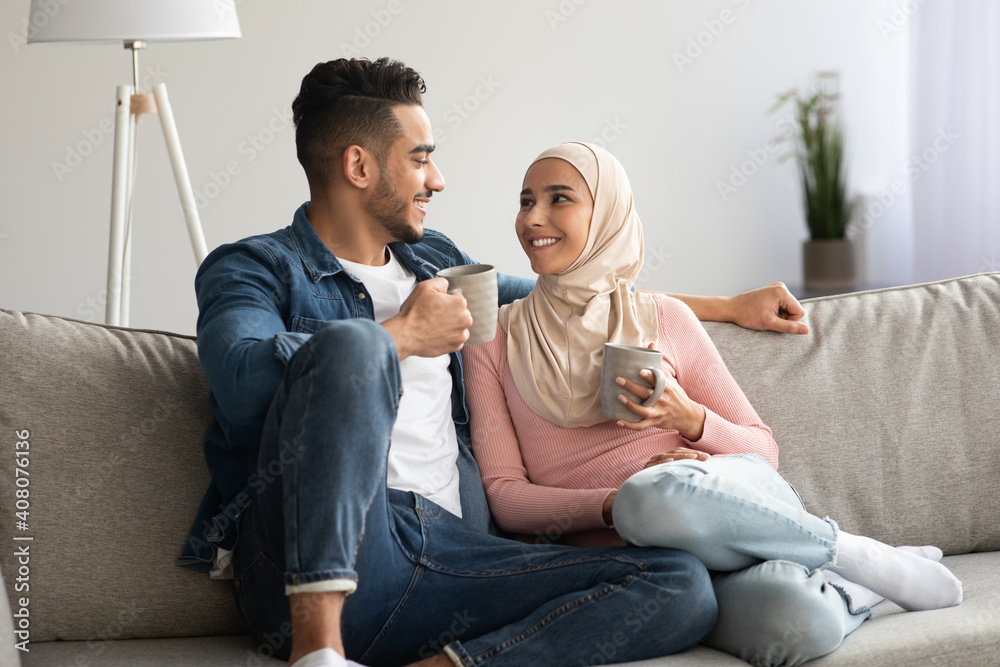 Muslim lovers drinking tea and talking at home
