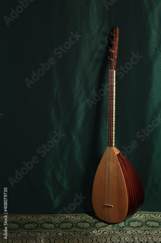 traditional Turkish national musical instrument baglama saz on a dark green background. a magnificent century. The concept of Islam photo