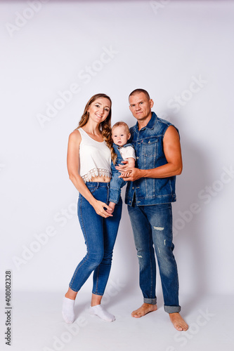 young parents and one-year-old girl on a white background