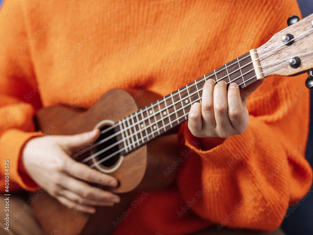 Fototapeta premium Girl playing the ukulele, close-up
