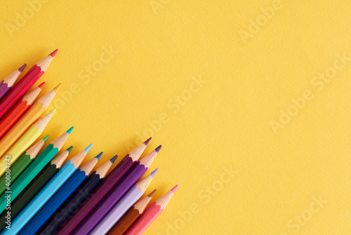 Colored pencils on the yellow background