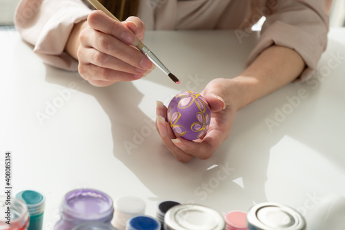 Wall Mural young beautiful asian woman using paint brush to decorate easter eggs for celebr