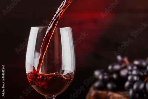 Filling a glass of red wine. Photo with selective focus.