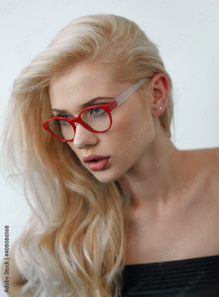 Close up portrait of a beautiful blonde girl with makeup wearing eyeglasses, looking a side, with bare shoulders, over white background. Close up portrait of a beautiful blonde girl with makeup wearing eyeglasses, looking a side, with bare shoulders, over white background.