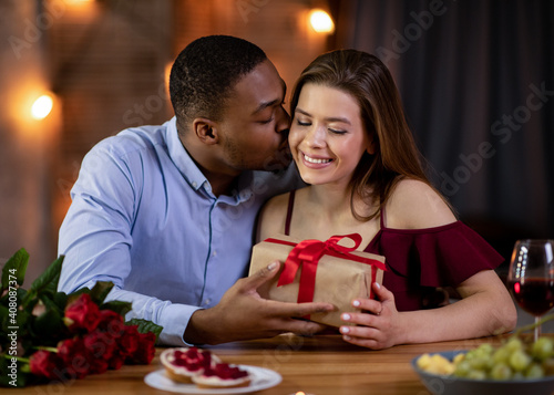 Loving african boyfriend making romantic present for his girlfriend on valentine's day