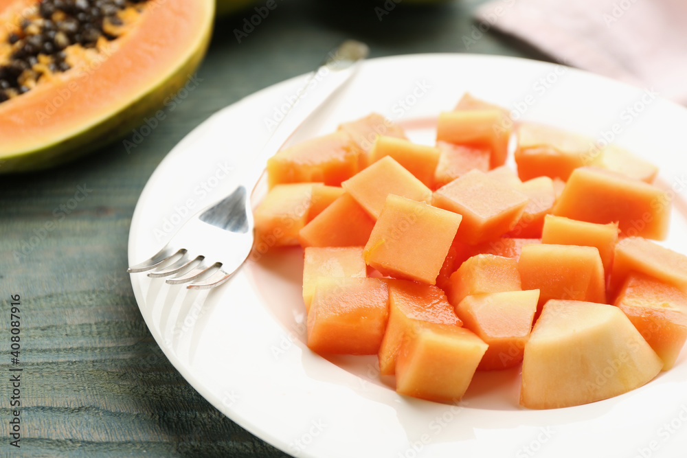 Plate with diced papaya on table, closeup Plate with diced papaya on table, closeup