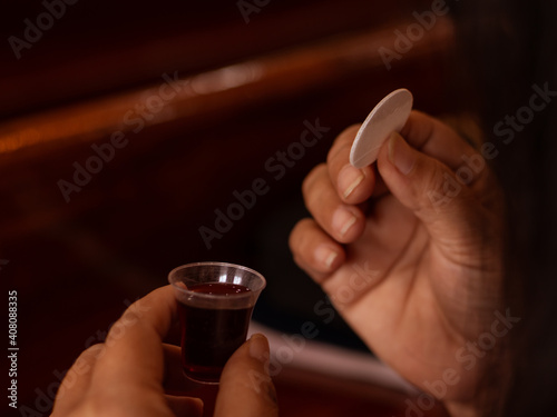 The image of a hand holding bread and wine During the Eucharist, Holy Communion in the church on sunday.