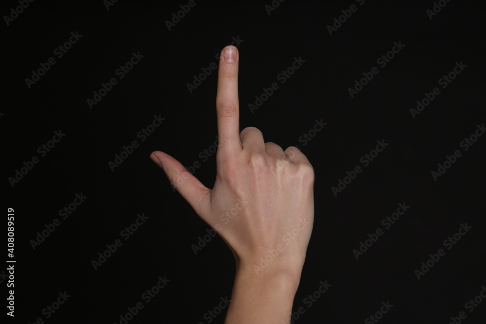 Woman pointing at something on black background, closeup. Finger gesture Woman pointing at something on black background, closeup. Finger gesture