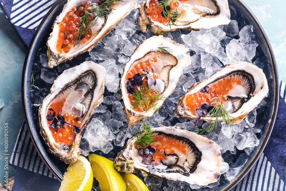 Oysters platter with lemon caviar and ice served on a Blue marine table. Oysters platter with lemon caviar and ice served on a Blue marine table.