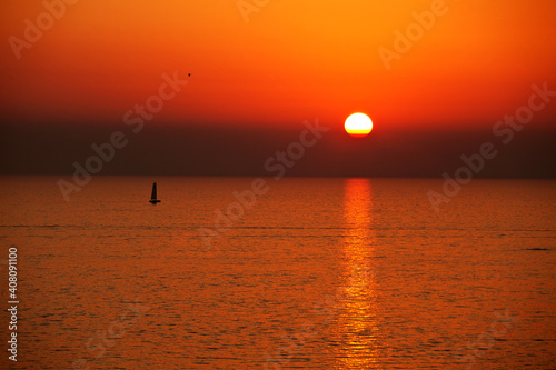 Sunset over Ocean with Sailing Yacht