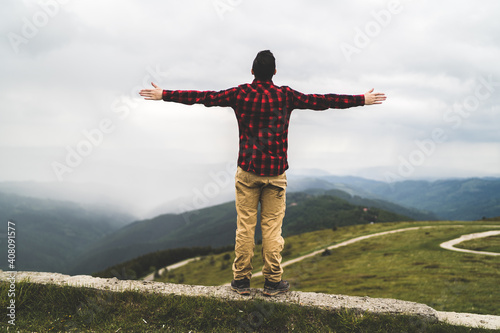 Man standing on top of mountain peak