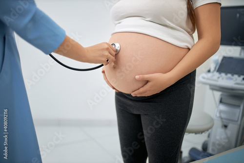 Female doctor measuring pregnant woman's tummy