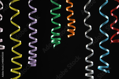 Many colorful serpentine streamers on black background