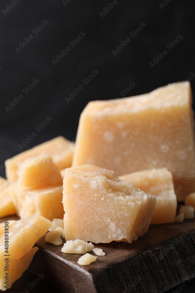 Pieces of delicious parmesan cheese on wooden board, closeup Pieces of delicious parmesan cheese on wooden board, closeup
