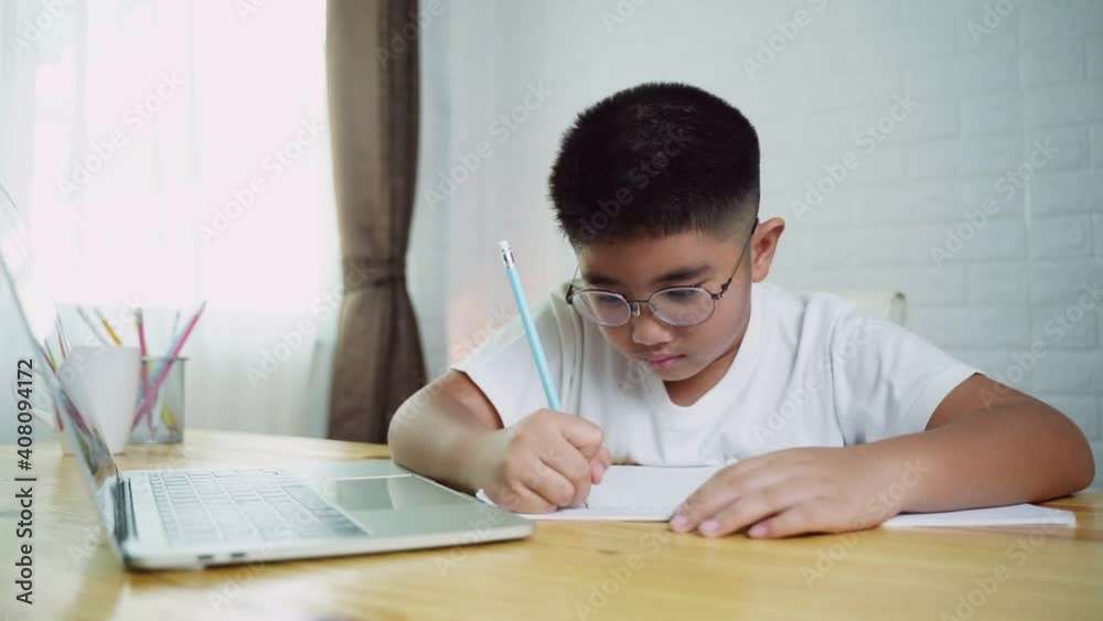 Asian boy student online learning class study online with laptop at home. Asian boy student online learning class study online with laptop at home.