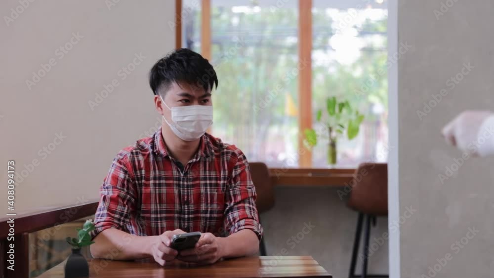 Businessman customer sitting play smartphone waiting for receiving coffee from waitress with face mask Businessman customer sitting play smartphone waiting for receiving coffee from waitress with face mask