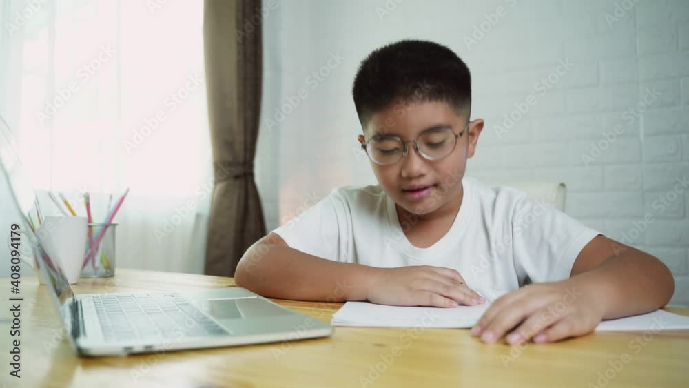 Asian boy student online learning class study online with laptop at home. Asian boy student online learning class study online with laptop at home.