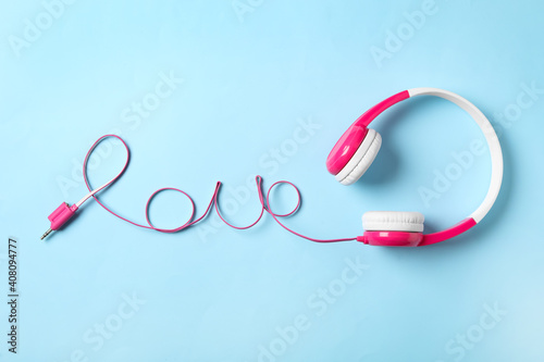 Word Love made with cable of headphones on light blue background, top view. Listening music songs