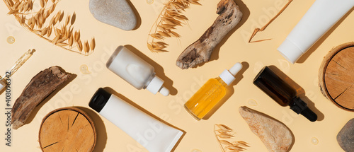 Natural cosmetic concept with serum and cream tube and bottles with natural materials