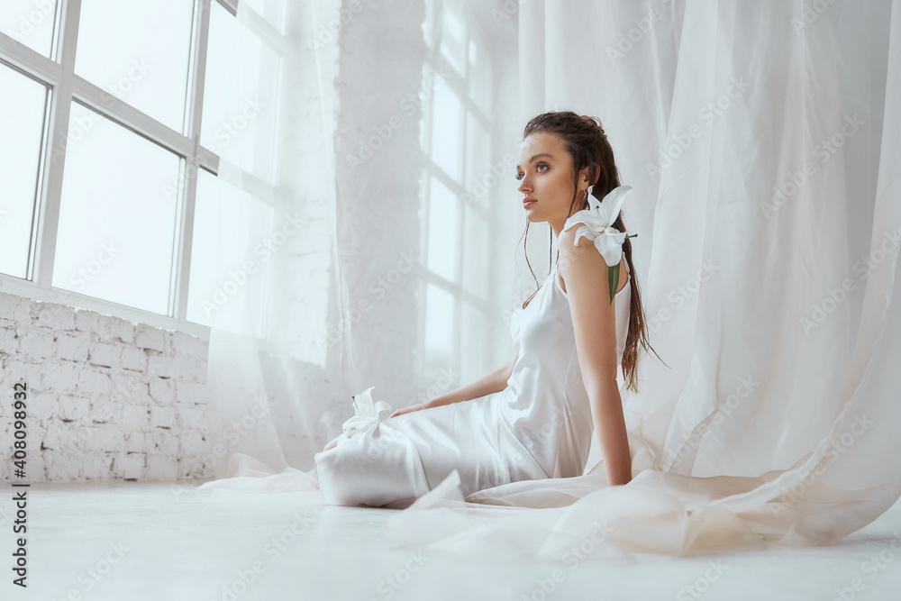 Young girl in silk dress sitting on floor. Young girl in silk dress sitting on floor.