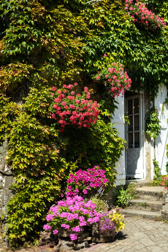 Flower-covered stone facade in France.