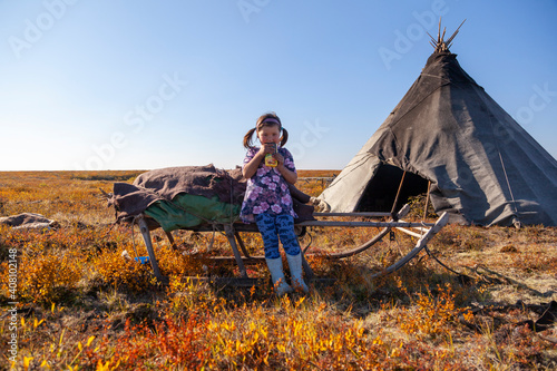 The extreme north, Yamal, the past of Nenets people, the dwelling of the peoples of the north, a girl playing near the yurts in the tundra