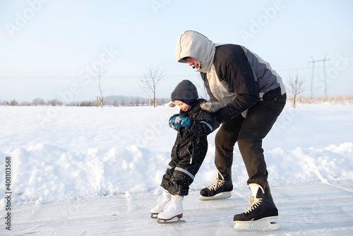 Obraz na plátně Grandfather teaching her little grandson ice skating at outdoor skating rink