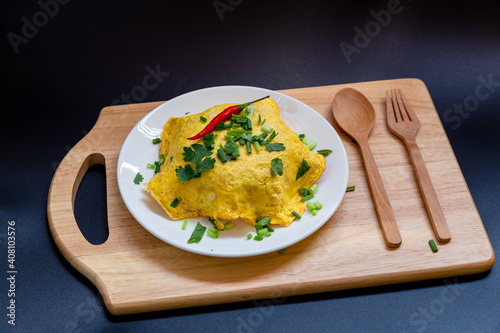 Omelette in white plate isolated on black background.