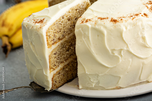 Photography A slice of banana cinnamon layered cake with cream cheese frosting