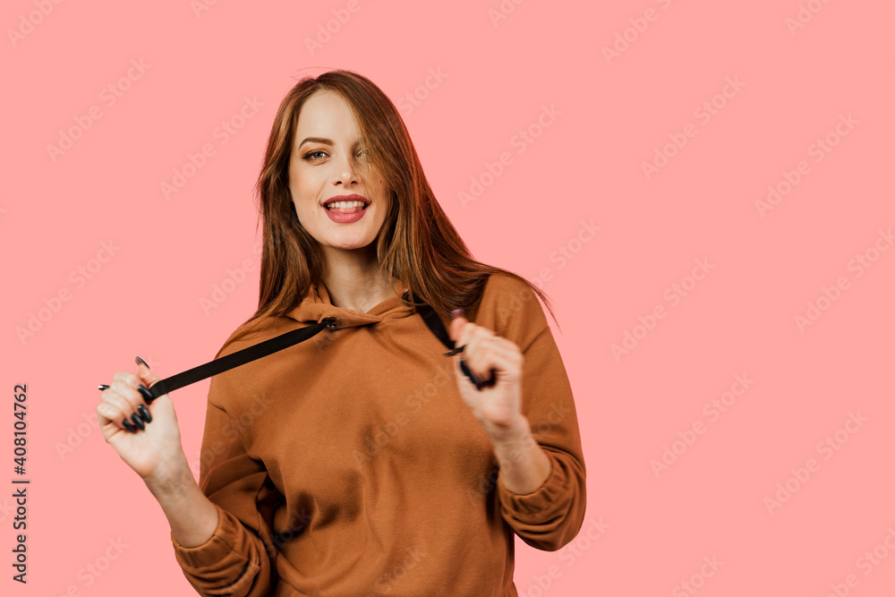Life style. Inspired and happy woman smiles, laughs and grimaces on pink background. Model posing in a photo studio. Girl weared brown oversize costume Life style. Inspired and happy woman smiles, laughs and grimaces on pink background. Model posing in a photo studio. Girl weared brown oversize costume