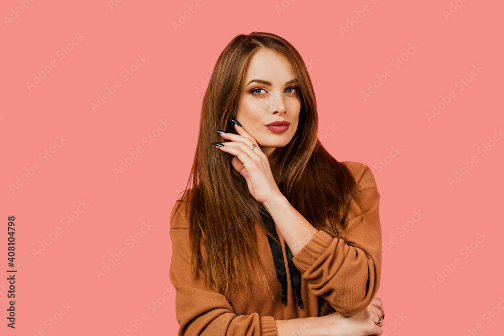 Tenderness and sensuality of a girl in a brown oversized suit on a pink background. Lifestyle. Cute and gentle young woman portrait. Beauty industry. Tenderness and sensuality of a girl in a brown oversized suit on a pink background. Lifestyle. Cute and gentle young woman portrait. Beauty industry.