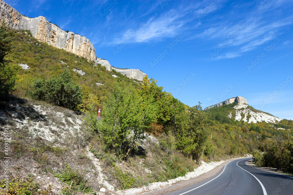 autumn view of landscape with limestone cliffs under blue sky and clouds