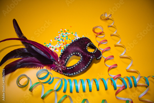 Slika na platnu purple carnival mask with confetti on a yellow background