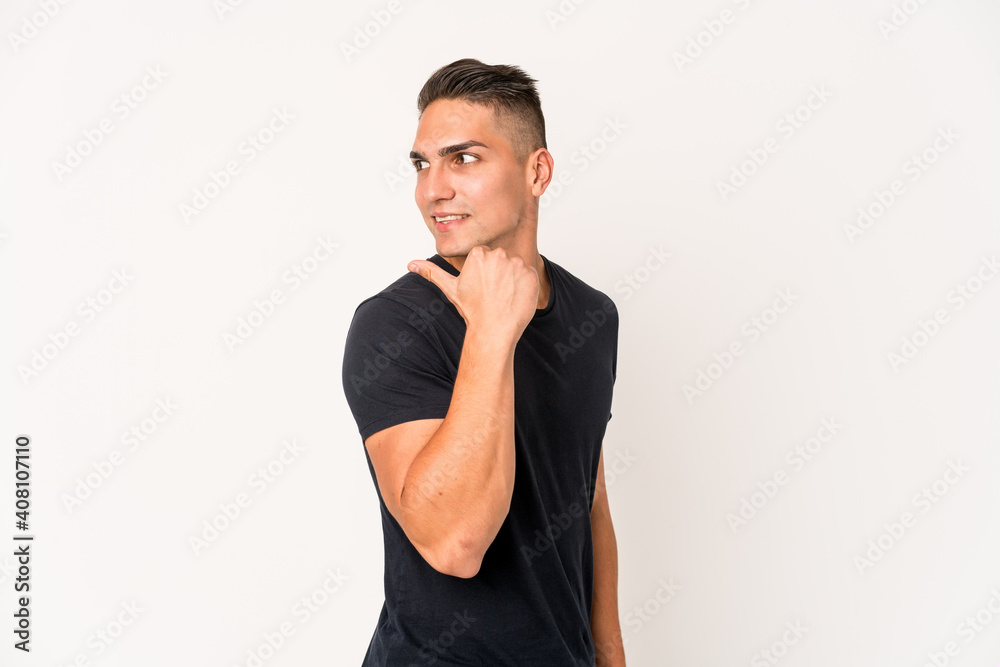 Young caucasian handsome man isolated points with thumb finger away, laughing and carefree. Young caucasian handsome man isolated points with thumb finger away, laughing and carefree.