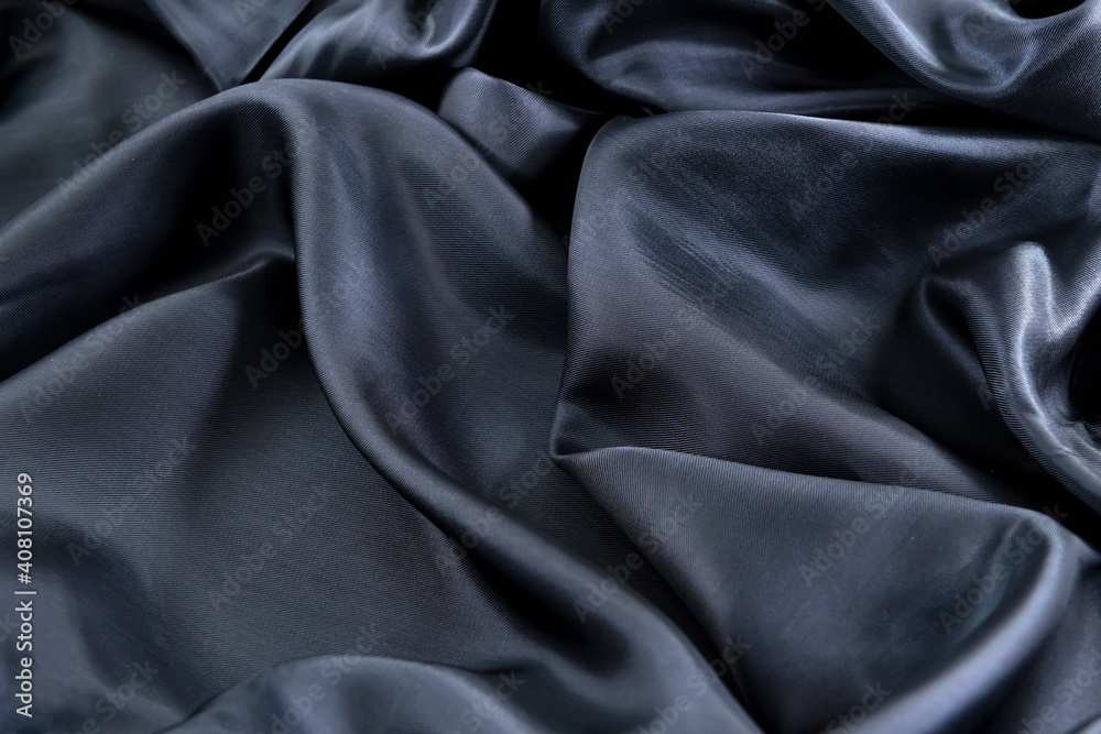 Fototapeta premium part of the dark fabric texture of the fabric for the background and design of the artwork, a beautiful crumpled pattern of silk or linen. A crumpled piece of cloth